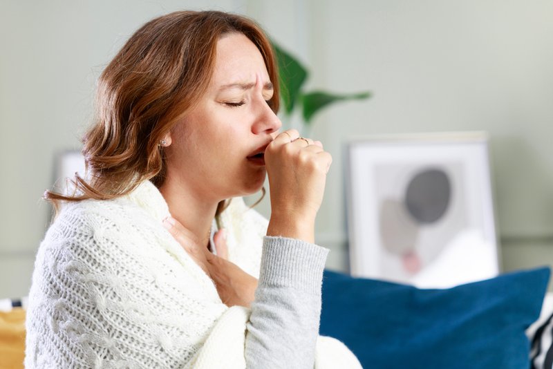Woman coughing, sore throat