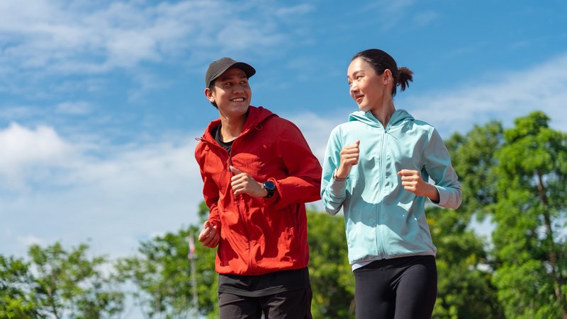 Young adult couple out jogging as part of their preventive care checklist